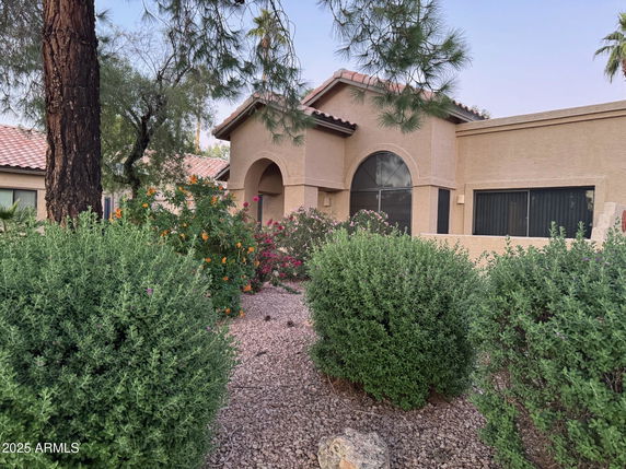 Front view of a single-story house with arched windows and a tiled roof.
