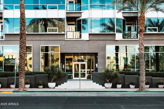 Front view of a modern building with large glass windows and entrance doors.