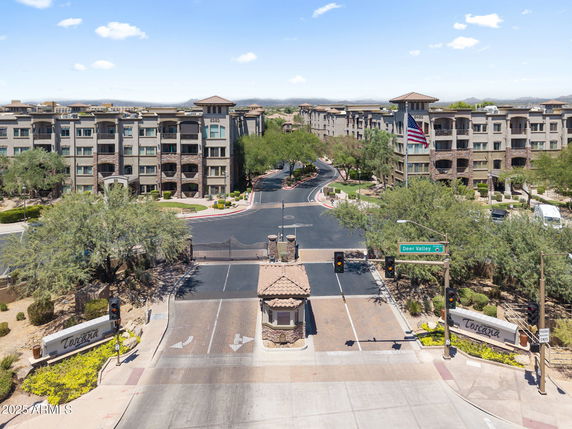 Front view of a large apartment complex with multiple buildings and gated entrance.