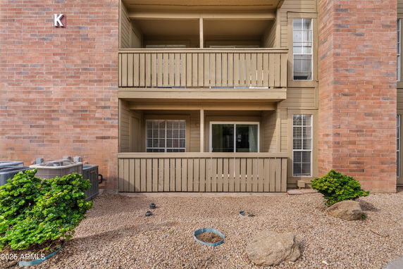 Front view of a multi-story building with balconies and brick exterior.