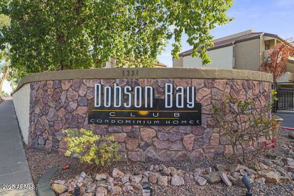 Front view of a stone wall with signage for Dobson Bay Club Condominium Homes.