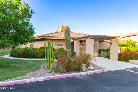 Front view of a building with a covered entrance and desert landscaping.