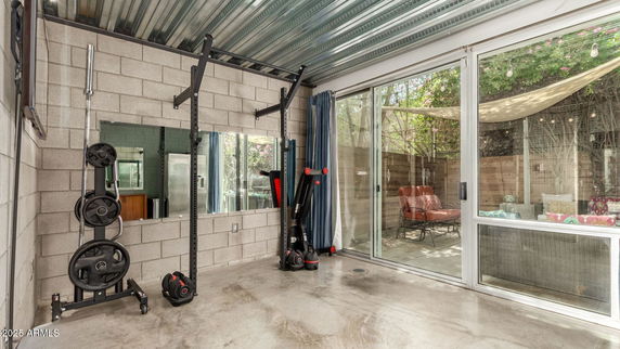Indoor gym area with exercise equipment and large sliding glass doors.