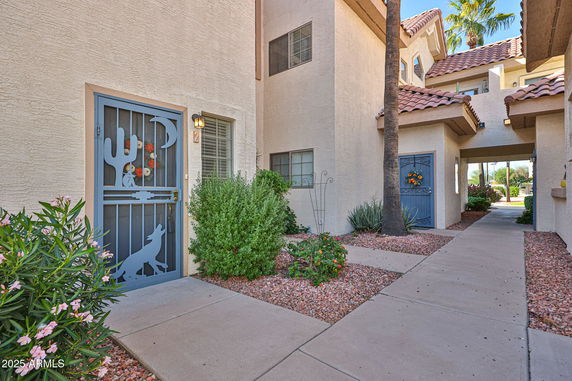 Front view of a residential building with decorative doors and plants.