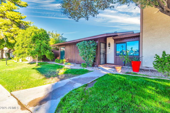 Front view of a single-story house with a wooden exterior and large window.