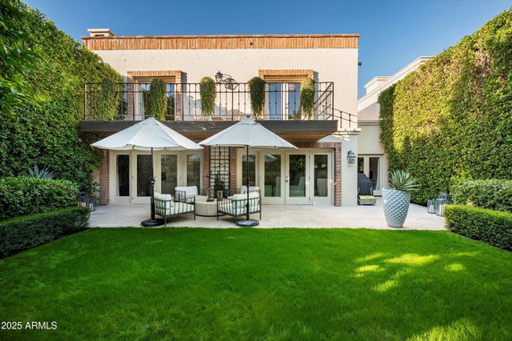 Front view of a two-story house with a patio and balcony.