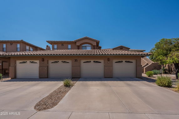 Front view of a two-story house with a tile roof and a double garage.