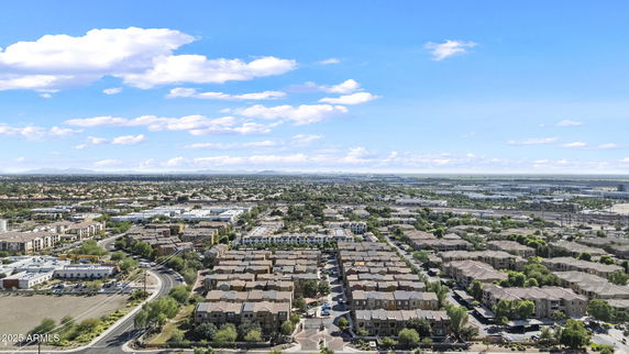 Panoramic view of a residential area with multiple houses and surrounding buildings.