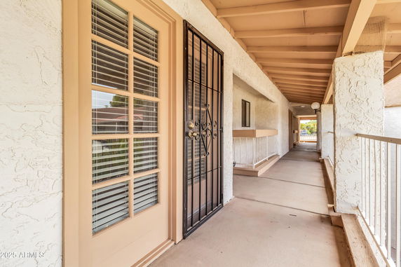 Front view of a building hallway with a secure door and railings.