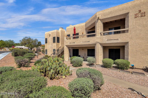 Front view of a two-story building with a beige facade and balconies.