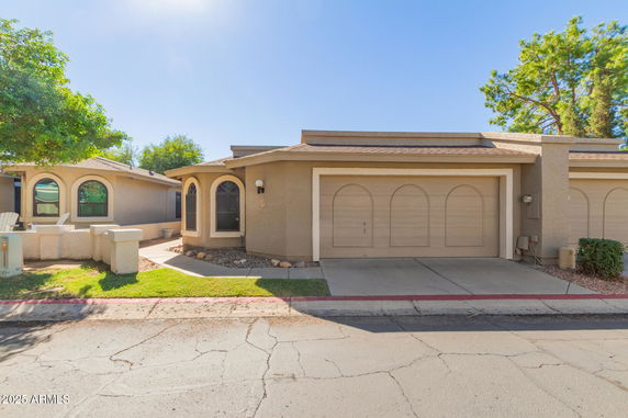 Front view of a house with a double garage and arched windows.