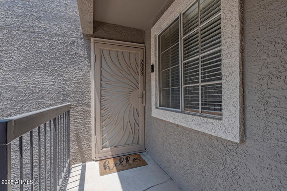 Front view of a house entrance with a decorative metal door.