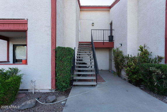 Front view of a two-story building with an exterior staircase.