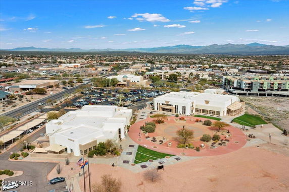 Panoramic view of a cityscape with buildings and parking areas.