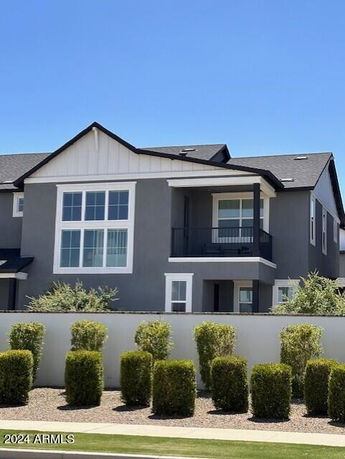 Front view of a two-story house with large windows and a balcony.