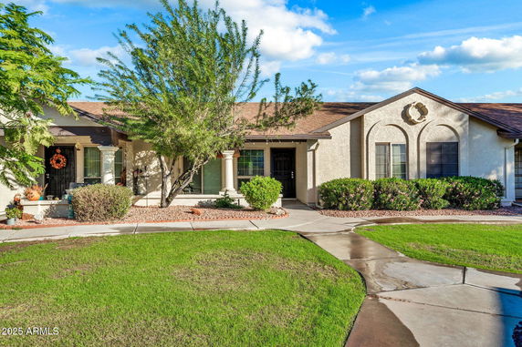 Front view of a single-story house with a curved path and landscaped garden.