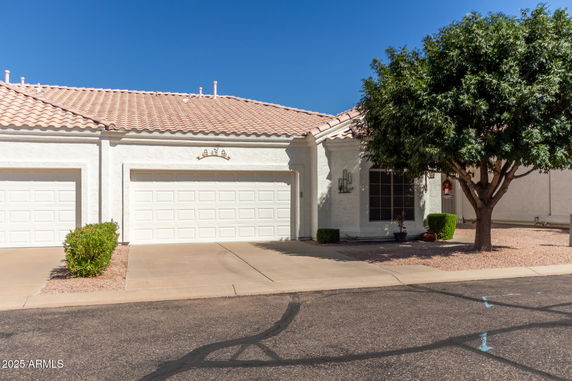 Front view of a single-story house with a two-car garage and tile roof.