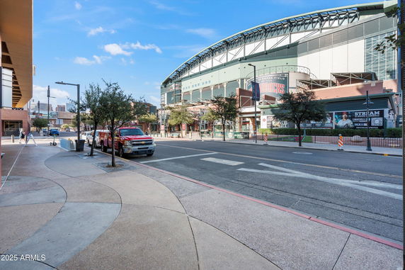 Front view of a large sports stadium with an arched roof and multiple entrances.