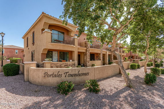 Front view of a row of townhomes with balconies and decorative stone accents.