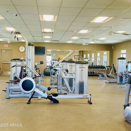 Indoor gym area with exercise equipment and mirrors.