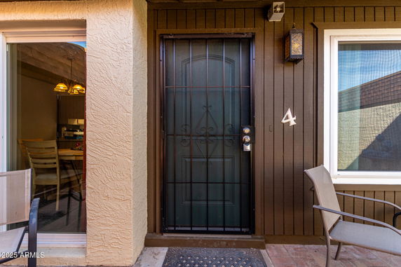 Front view of a building entrance with a security door and adjacent window.