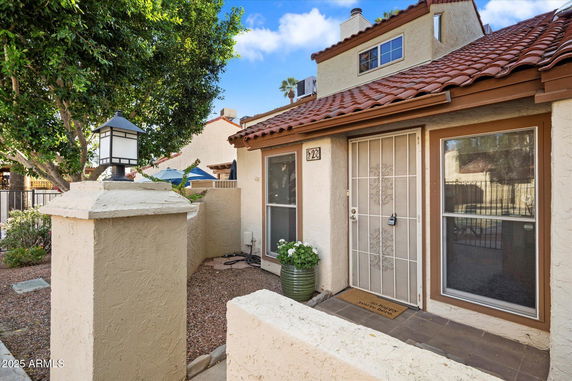 Front view of a house with a white entrance door and red-tiled roof.