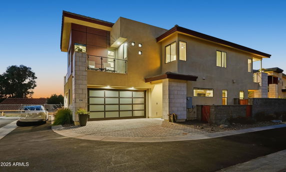 Front view of a modern two-story house with a balcony and garage.