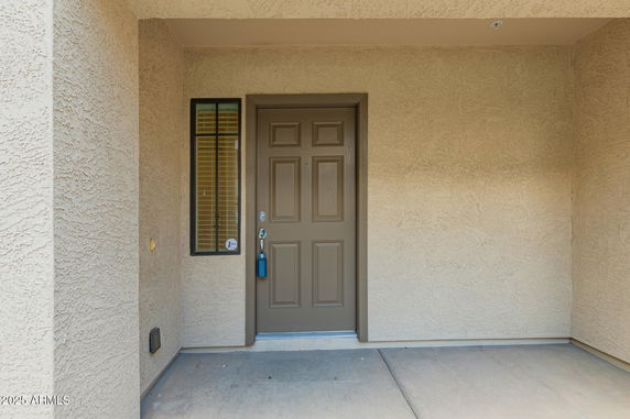 Front view of a house entrance with a brown door and small window.
