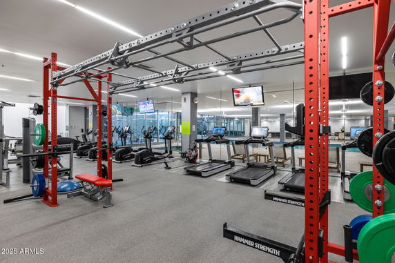 Indoor gym with exercise equipment including treadmills and weightlifting stations.