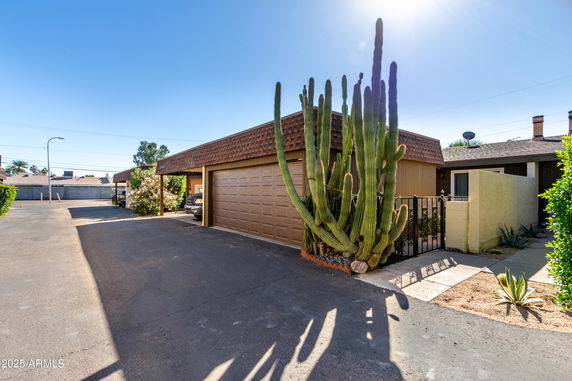 Front view of a house with a double garage and large cactus plants.
