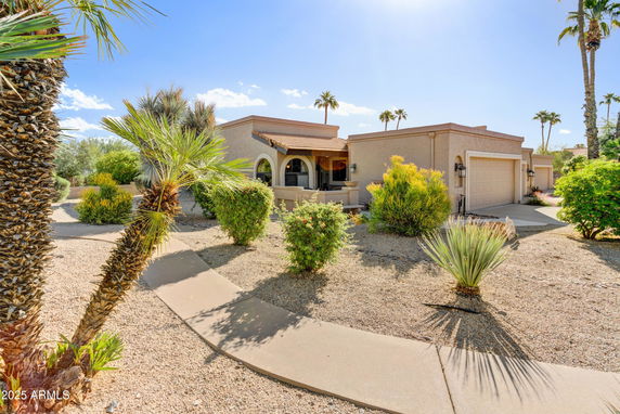Front view of a single-story house with desert landscaping and a double garage.