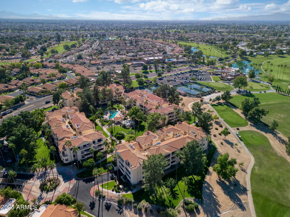Wide-angle aerial view of a residential complex with adjacent green spaces and surrounding neighborhoods.
