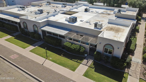 Aerial view of a flat-roofed building with multiple HVAC units on top.