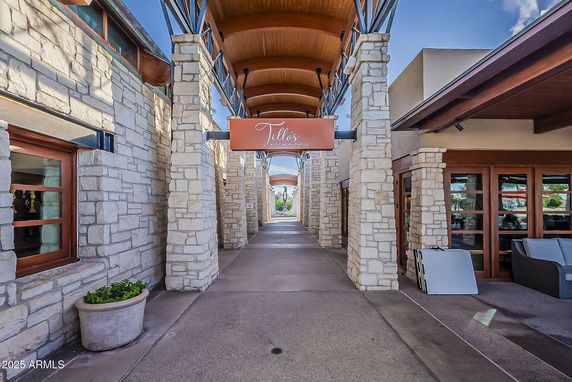 Front view of a commercial walkway with stone pillars and wooden accents.