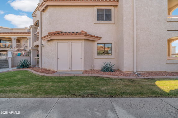 Front view of a two-story house with textured walls and tile roofing.