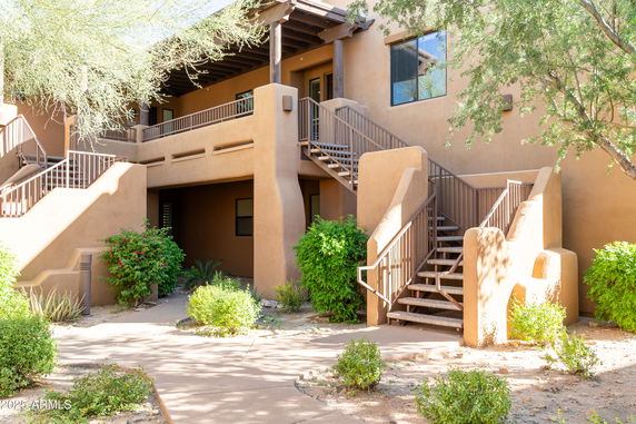 Front view of a two-story building with stucco exterior and external staircases.