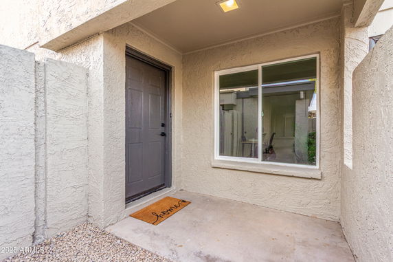 Front view of an entryway with a gray door and a window.