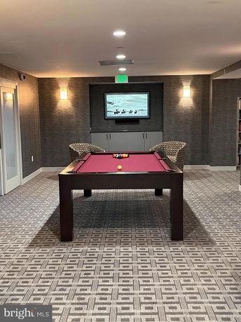 Interior view of a club house room with a billiards table and chairs.