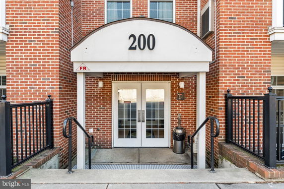 Front entrance of a brick building with double doors and a number 200 above.