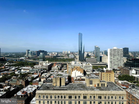 Panoramic view of a cityscape with tall buildings and a clear sky.