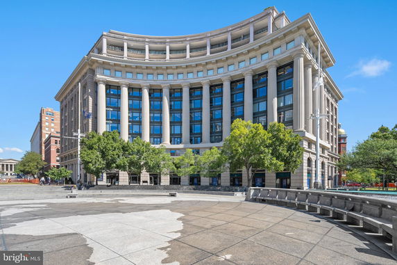 Front view of a multi-story building with tall columns and a curved facade.