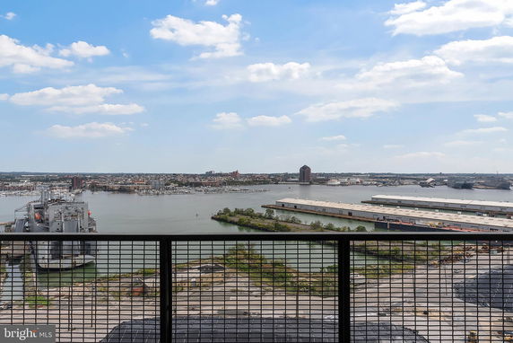 Panoramic view of a harbor with ships, buildings, and water seen from a high vantage point.