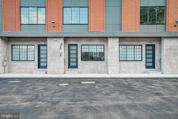 Front view of a modern multi-story building with brick and concrete facade.