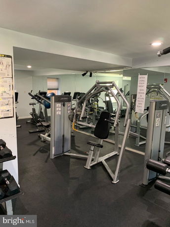 Interior view of a gym area with exercise machines and weights.
