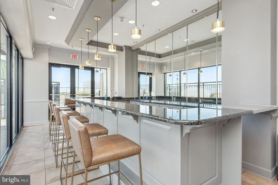 Interior view of a club house with bar seating and pendant lights.