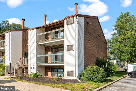 Front view of a three-story apartment building with balconies.