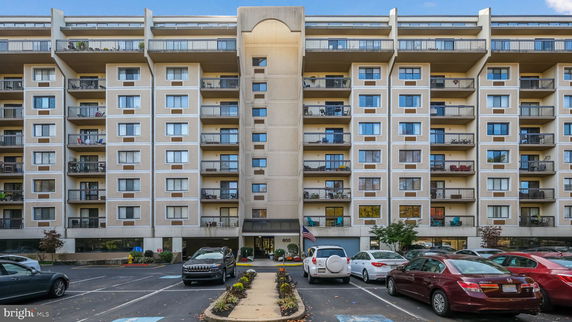 Front view of a multi-story apartment building with balconies.
