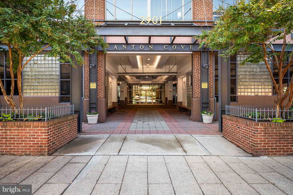 Entrance view of a multi-story building with brick and glass facade.