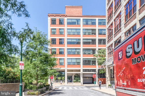 Front view of a multi-story brick building with large windows.