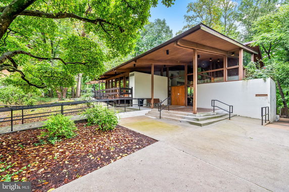 Front view of a modern house with large windows and wooden accents.